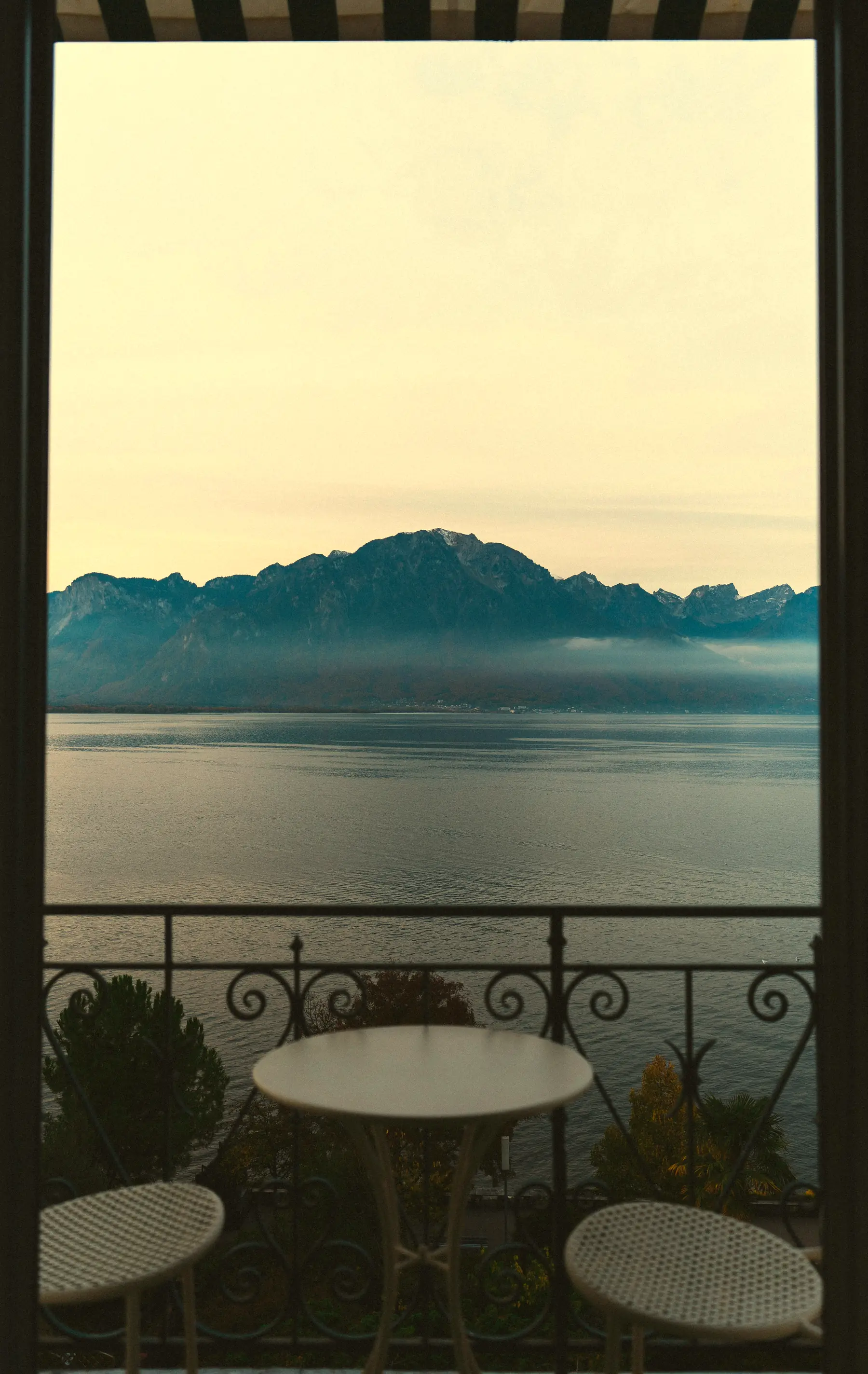 Ein gedeckter Balkontisch für zwei mit Blick auf den Genfersee und die Berge