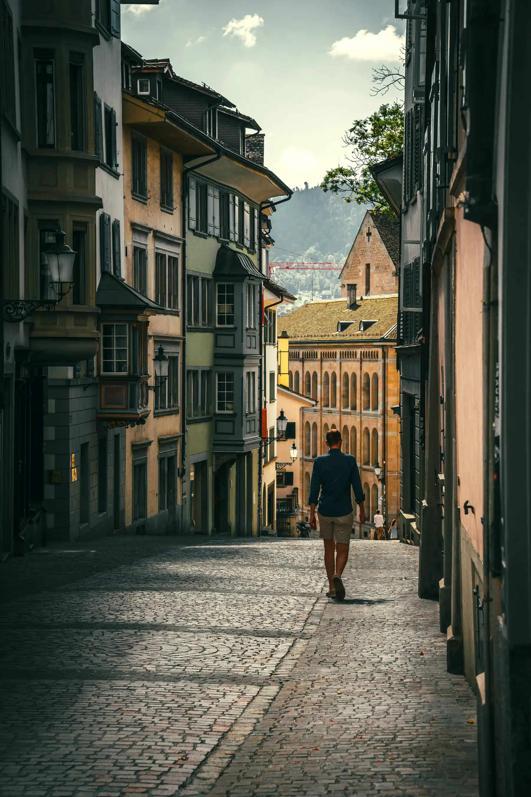Ein Mensch geht durch eine Pflastergasse in der Zürcher Altstadt